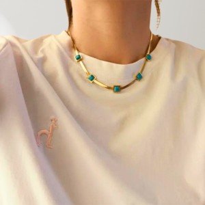 Collier Neptune, collection LES ROCHEUSES par AIFEE Jewelry. Collier en titane inoxydable trempé or jaune et serti de belles turquoises naturelles taillées de forme carré. Collier NEPTUNE disponible en vente en ligne sur le site AIFEE Jewelry.